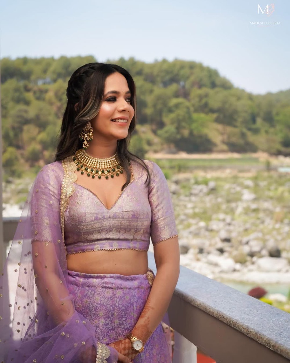 Guest in a lilac lehenga with a kundan choker and soft glam makeup by a Himachal riverside