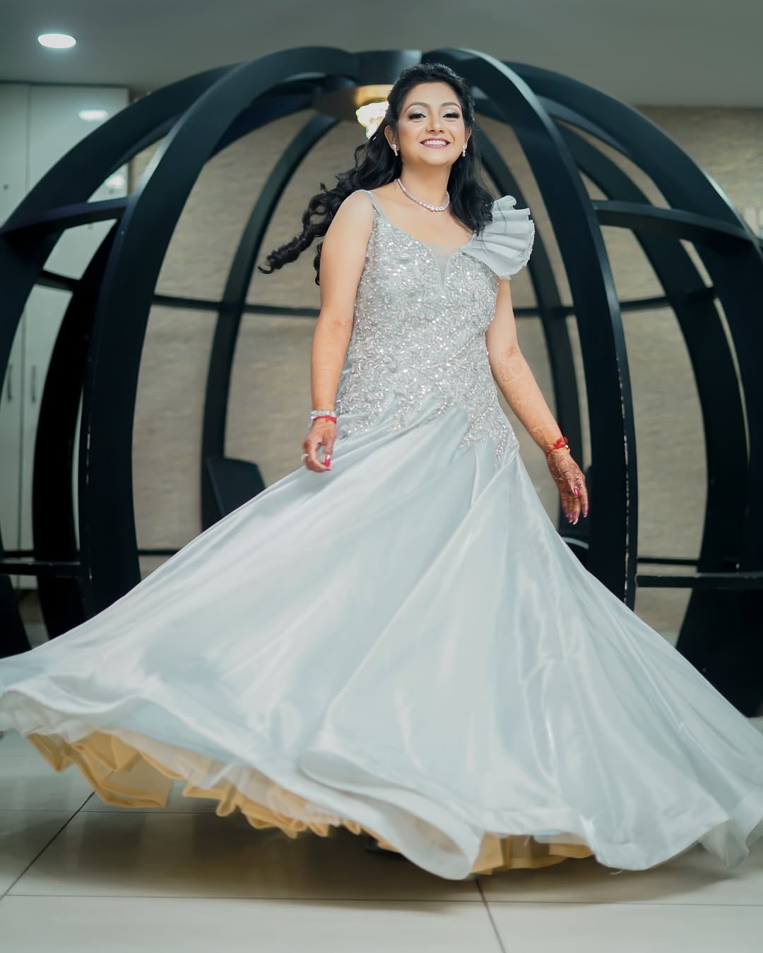 Reception look — twirling in a silver embellished gown with soft curls